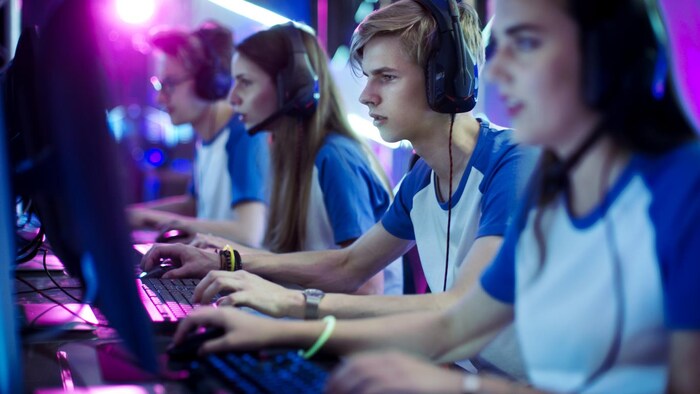 两个女孩和两个男孩组成的团队正在玩电脑。